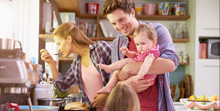 Busy parents cooking and entertaining children in the kitchen