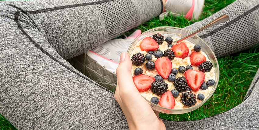 a person holding a bowl of oatmeal with berries