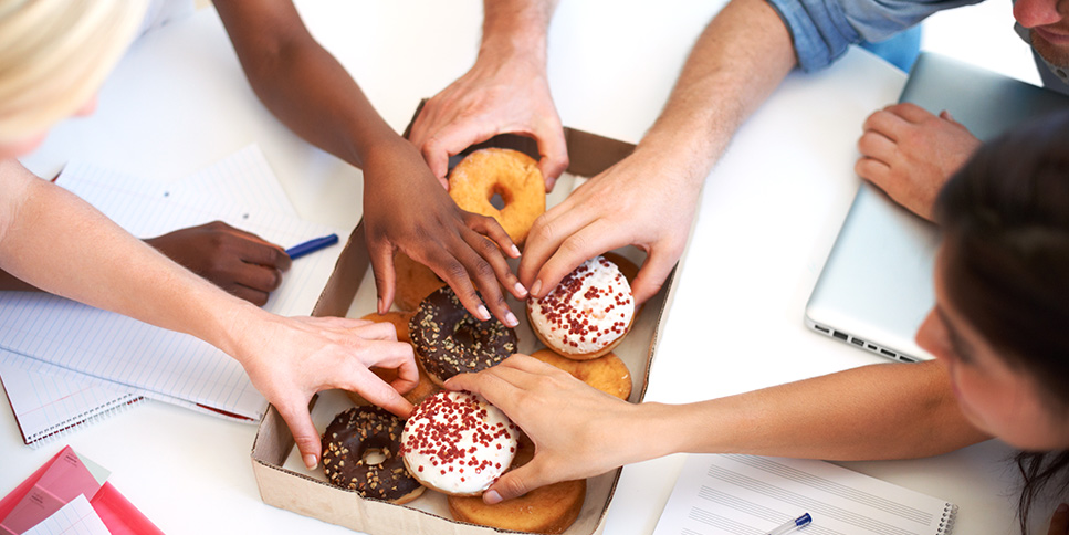 Office employees snacking on donuts