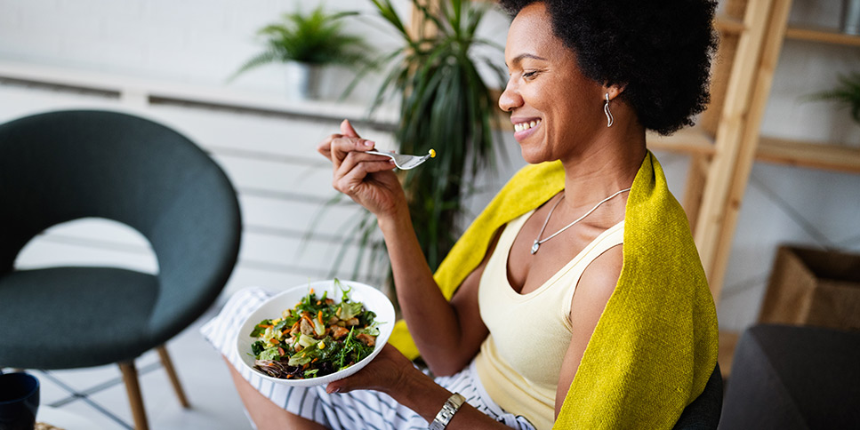 woman eating a healthy vegetable salad at home