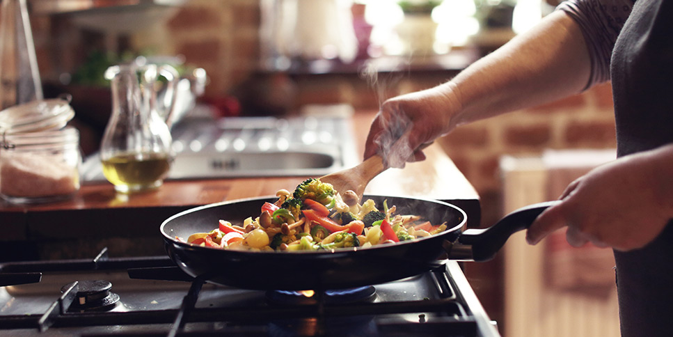 picture of a woman cooking vegetables
