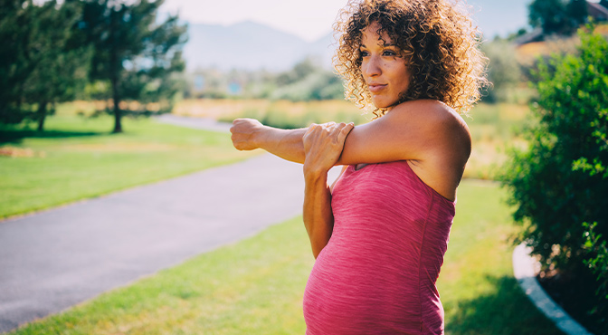 pregnant woman stretching outdoors