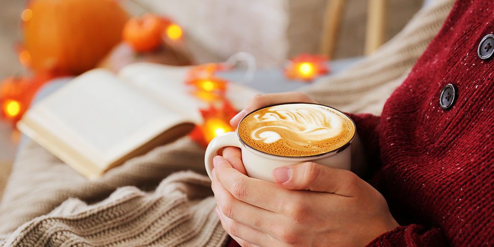 woman holding a mug of pumpkin spice latte