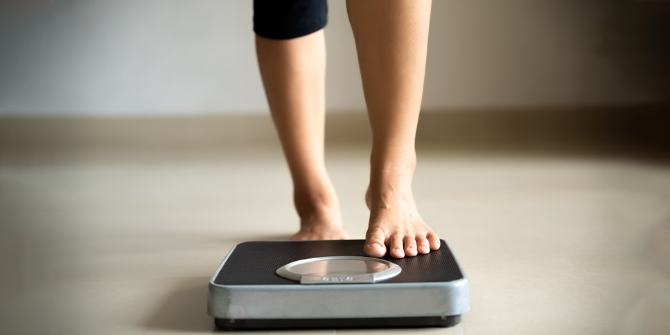 woman stepping onto the scale