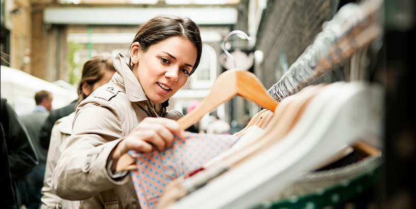 a woman looking at clothes on a rack